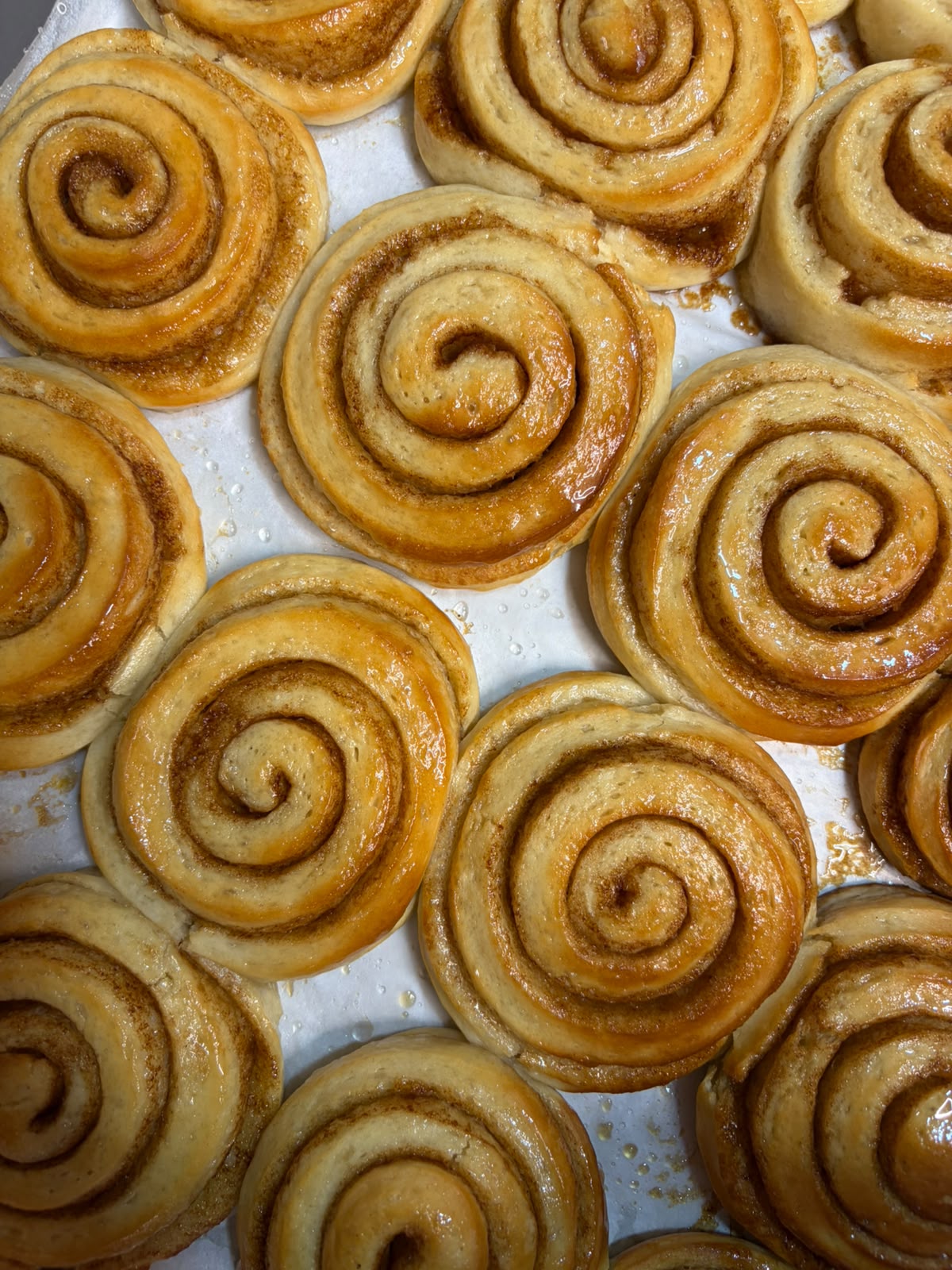 Bandeja de cinnamon rolls caseros recién horneados en Guiri's Barbate
