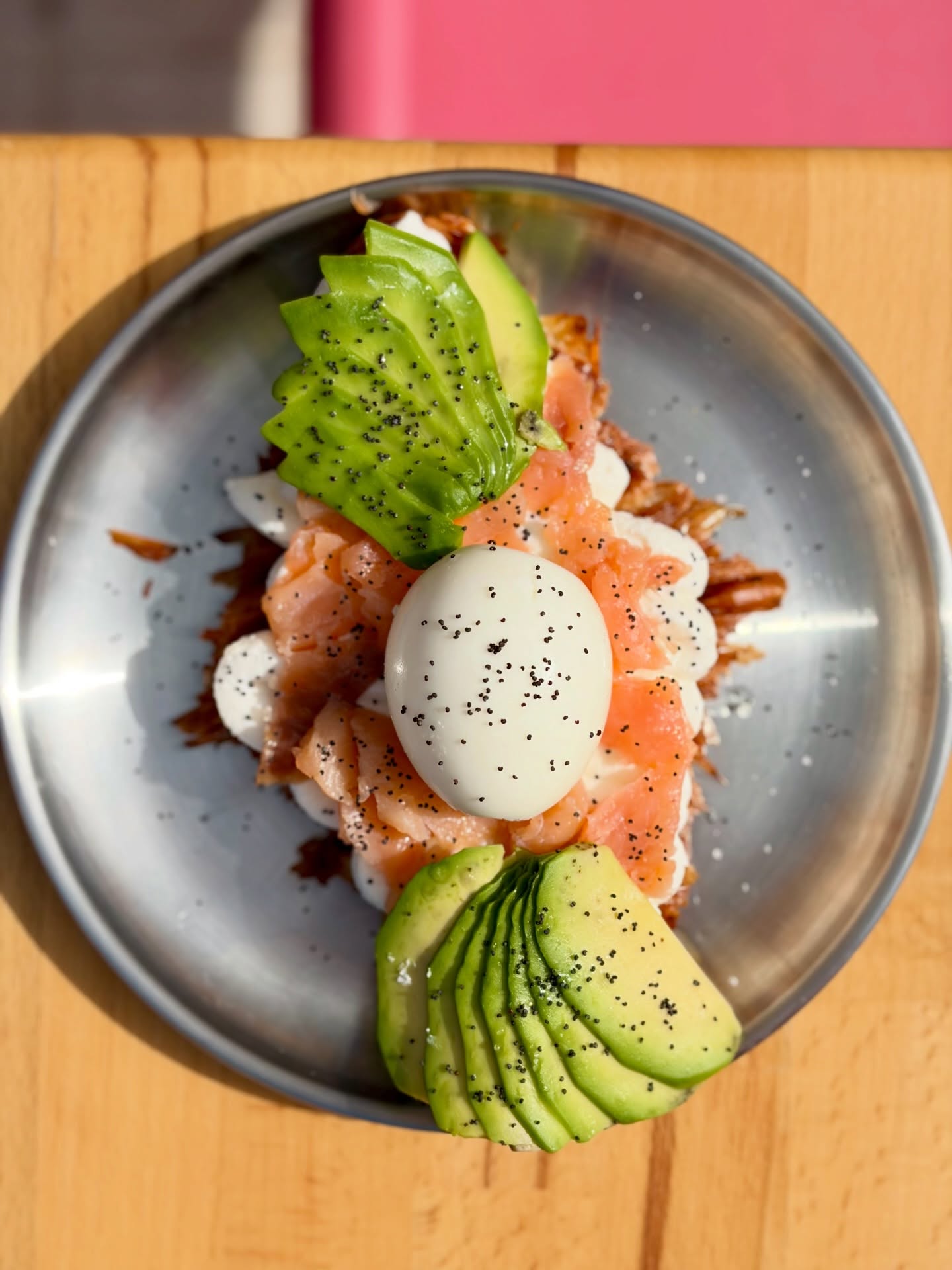 Croissant plano con salmón marinado, aguacate y huevo mollet