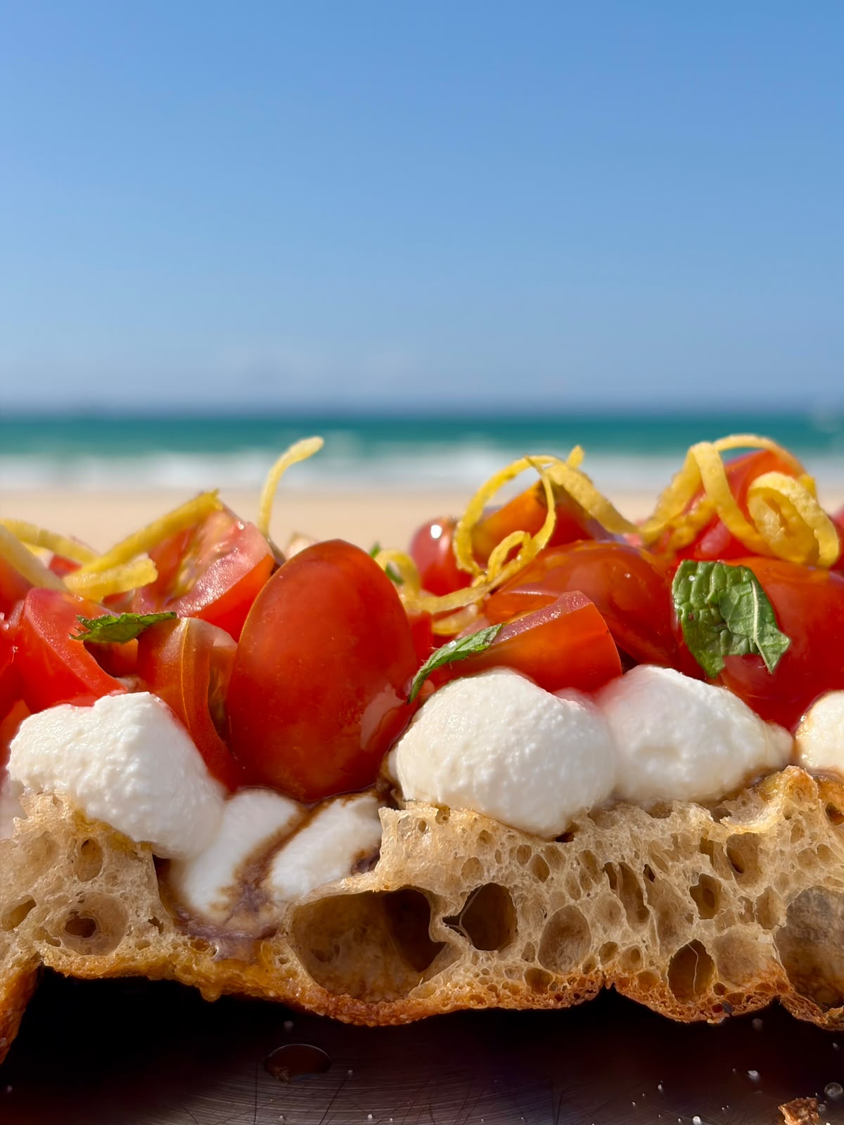 Focaccia con ricotta, tomates cherry y limón frente a la playa de Barbate