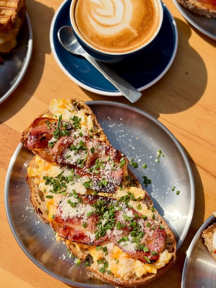 Tosta de huevos revueltos con bacon crujiente y flat white — cafetería Barbate