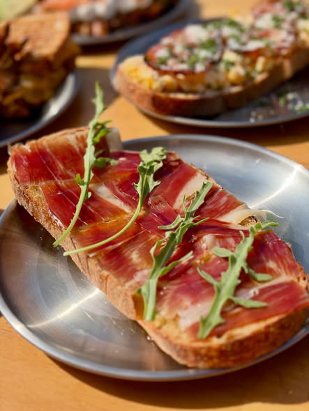 Tosta de masa madre con jamón curado y rúcula — brunch en Guiri's Barbate